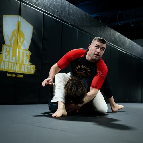 No-Gi grappling session at Elite Martial Arts, with one athlete controlling their opponent from a dominant position on the mat.